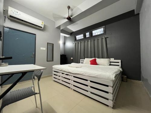 1 dormitorio con cama blanca y almohada roja en Urban Inn Rukminigaon en Guwahati