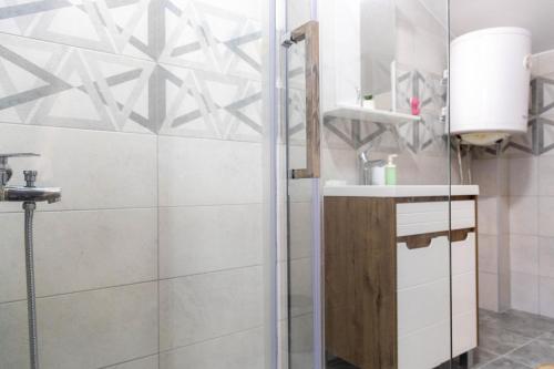 ein Bad mit einer Dusche und einem Waschbecken in der Unterkunft Apartmani Vajati Gradac in Valjevo