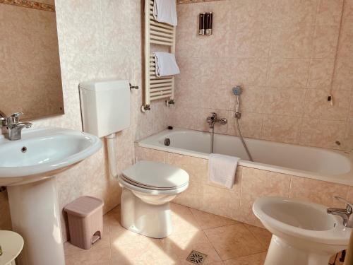 uma casa de banho com um WC, um lavatório e uma banheira em Alla Corte Rossa em Veneza
