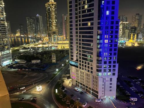 a view of a city at night with a tall building at Hostel - bedspace for Ladies سكن - سرير للبنات in Al Khān