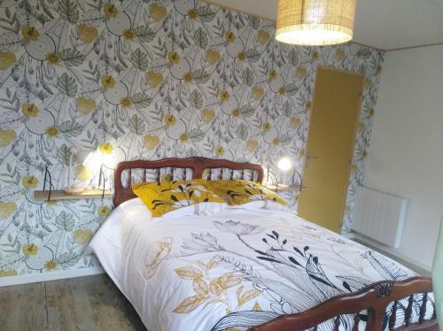 une chambre avec un lit avec un papier peint fleuri dans l'établissement Appartement cozy dans maison privée, à Tauves