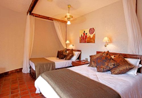 a hotel room with two beds in a room at Tarangire Sopa Lodge in Madege
