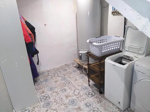 - une buanderie avec un lave-linge et un évier dans l'établissement Appartement cozy dans maison privée, à Tauves