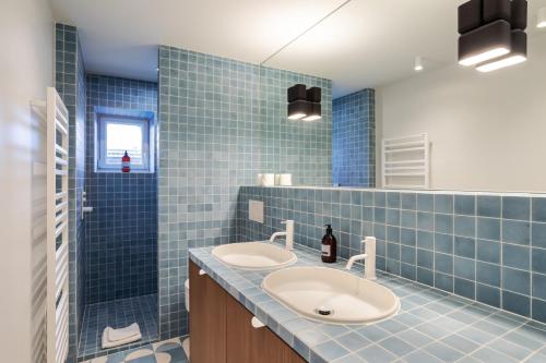サン・マロにあるL'Etoile du Roy by Cocoonrの青いタイル張りのバスルーム(シンク2台、シャワー付)