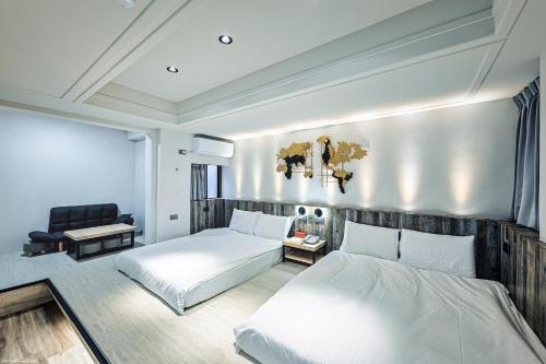 a bedroom with two beds and a chair in it at 亞馨文旅 近東大門夜市 有免費停車場 可自助入住 in Hualien City