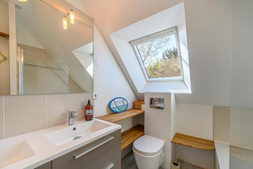 een badkamer met een wastafel en een raam bij Ker Anna - Maison proche plage pour 8 in Sarzeau