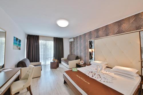 a hotel room with a bed and a desk at Prestige Deluxe Hotel Aquapark Club - All inclusive in Golden Sands
