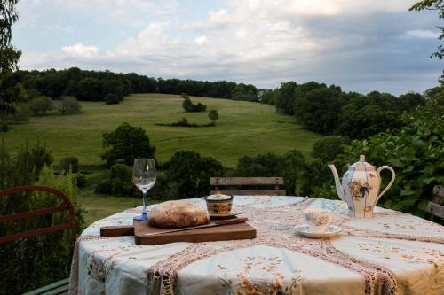a table with a vase and a glass of wine at Le Bourmier Anlhiac near Excideuil in Anlhiac