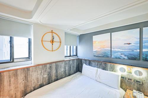 a bed in a room with windows and a clock at 亞馨文旅 近東大門夜市 有免費停車場 可自助入住 in Hualien City
