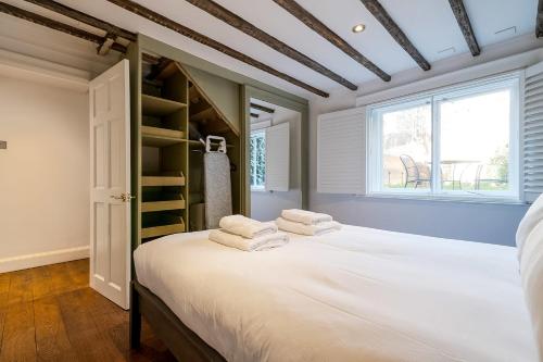 - une chambre avec un grand lit et des serviettes dans l'établissement Historic 18th Century Terrace House, à Londres