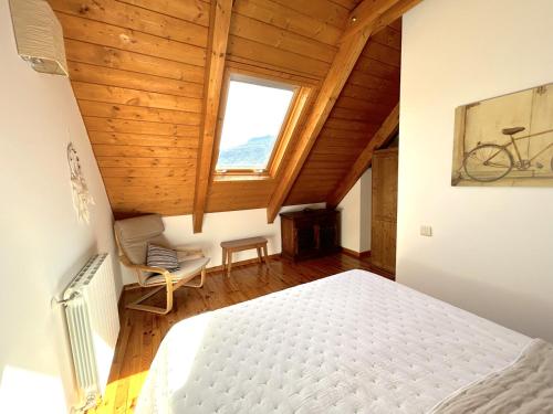 1 dormitorio con 1 cama y una bicicleta en la pared en Dúplex amb vistes fantàstiques al centre d'Esterri d'Àneu by RURAL D'ÀNEU, en Esterri d'Àneu