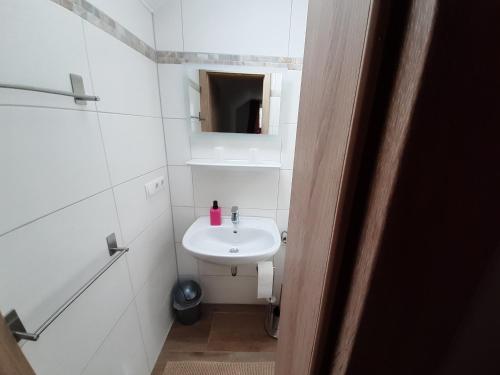 a small bathroom with a sink and a mirror at Bed and Breakfast 4 in Korswandt