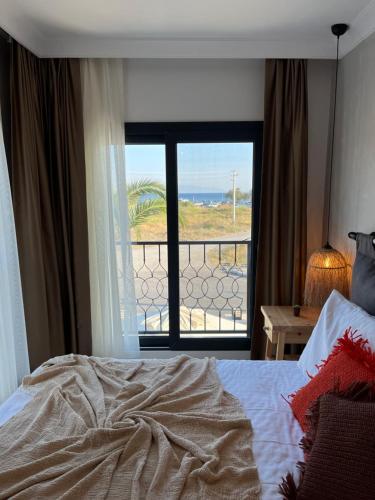 a bedroom with a bed and a view of the ocean at LAGOM HOTEL in Seferihisar