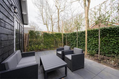 un patio con 2 sillas, una mesa y una valla en Vakantiehuis De Zeearend Dishoek, en Dishoek