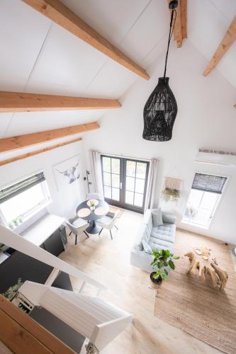 an attic living room with white walls and wooden beams at Vakantiehuis De Zeearend Dishoek in Dishoek