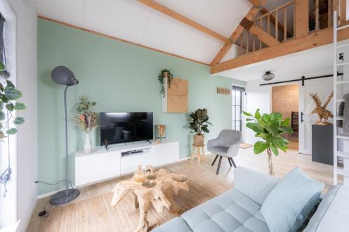 ディスフクにあるVakantiehuis De Zeearend Dishoekのソファとテレビのあるリビングルーム