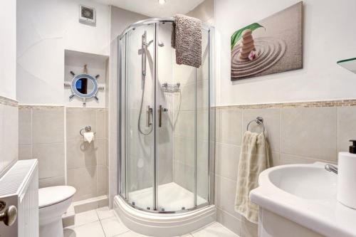 a bathroom with a shower and a toilet and a sink at The Saddlery Cheshire in Congleton