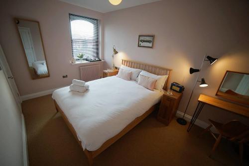 um quarto com uma grande cama branca e uma televisão em The Alma Taverns Boutique Suites Room 2 - Hopewell em Bristol