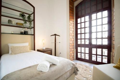 a bedroom with a white bed and a window at Palacete da Serenata @ Sé Velha in Coimbra