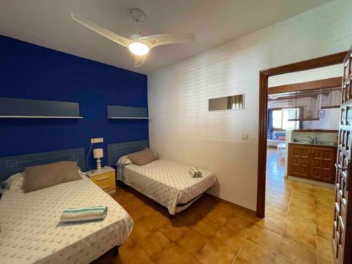 um quarto com 2 camas e uma parede azul em Tropikana Park VI em Denia