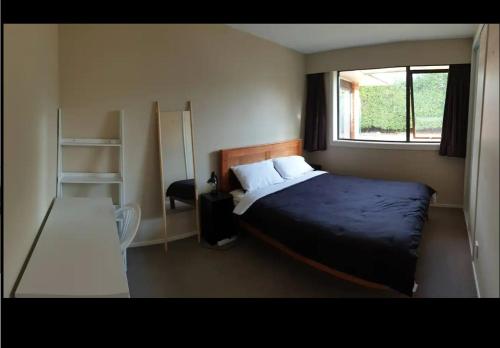 een kleine slaapkamer met een bed en een raam bij Highland Place Avonhead in Christchurch