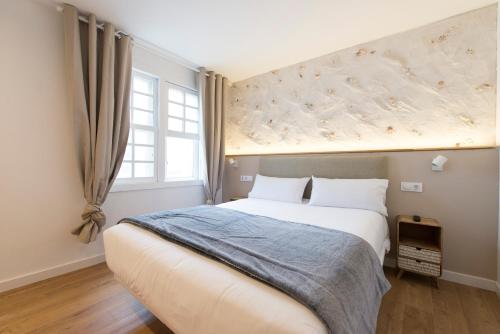 a bedroom with a large bed and a window at Hotel A Falúa in Puentedeume