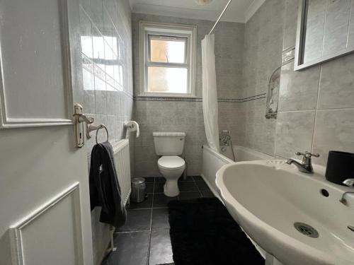 a bathroom with a white sink and a toilet at Sea views Family & Relocators by O & J Properties in Shoreham-by-Sea