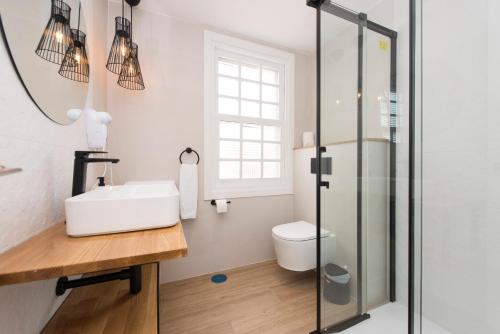 a bathroom with a sink and a glass shower at Hotel A Falúa in Puentedeume