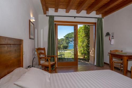 um quarto com uma cama, uma secretária e uma janela em Residence Ca Del Lago em Torri del Benaco