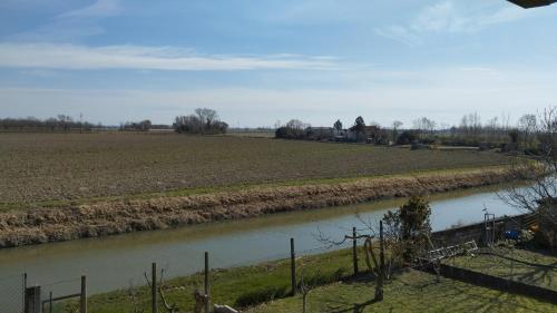 a view of a field and a river at Mansarda al mare in Pertegada
