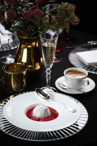 a table with a plate with a dessert on it at NARUTIS Hotel - Small Luxury Hotels of The World in Vilnius
