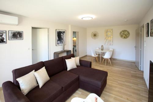 salon z brązową kanapą i stołem w obiekcie 2 Room Terraced Apartment Cannes Centre w Cannes