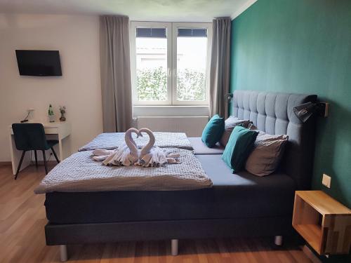Hotel Groote Engel في امليشهيم: غرفة نوم عليها سرير وبجعتين