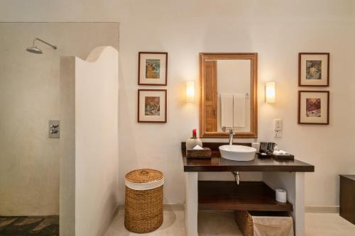 W łazience znajduje się umywalka i lustro. w obiekcie Taru Villas Rampart Street - Galle Fort w mieście Galle