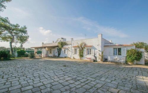 a large white house with a stone driveway at Villa Annabella - Vacanze Ostuni in Carovigno