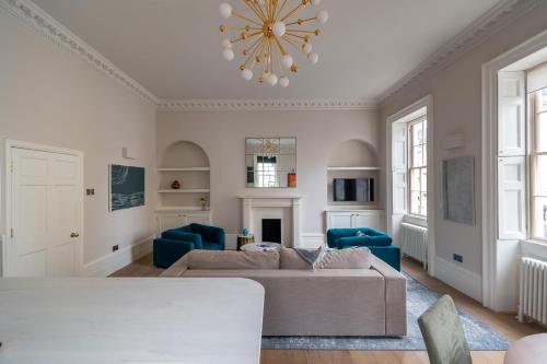 a living room with a couch and blue chairs at Russell House Suites in Bath