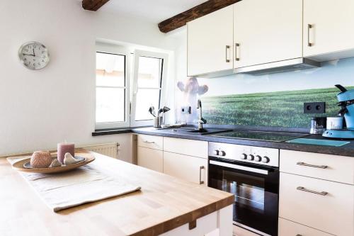 a kitchen with white cabinets and a counter top at Naturidyl Schneckenbuch in Weißensberg