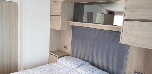 - une petite chambre avec un lit et un miroir dans l'établissement Boulevard, à Selsey