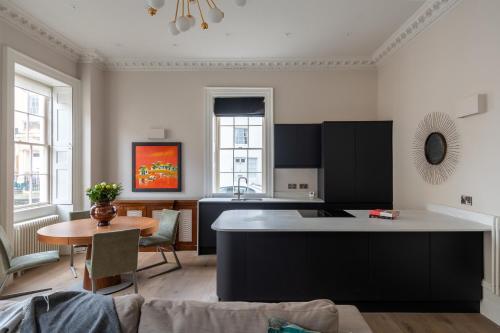 sala de estar con cocina y mesa en Russell House Suites en Bath