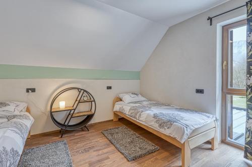 Habitación con 2 camas y espejo. en Resort Stari Malni, en Osilnica
