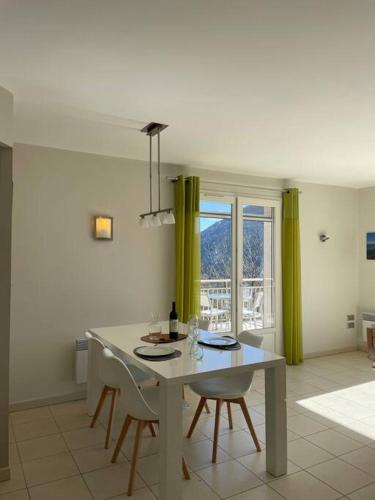 une salle à manger avec une table et des chaises et une fenêtre dans l'établissement Salvezines Villa, à Salvezines