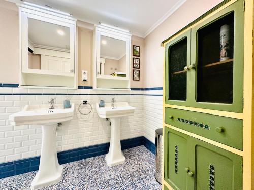 a bathroom with two sinks and a green door at BOOK DUPLEX REUS in Reus