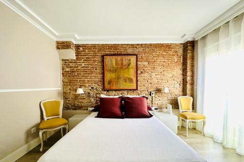 um quarto com uma cama grande e uma parede de tijolos em BOOK DUPLEX REUS em Reus