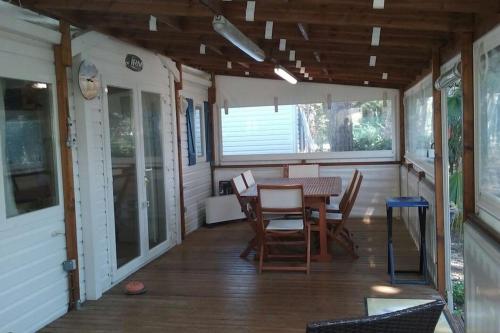 a screened in porch with a table and chairs at Mobilhome 6 personnes en bord de mer in Hyères