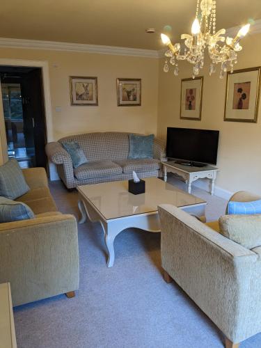a living room with couches and a coffee table at Dalhousie Castle Hotel in Bonnyrigg