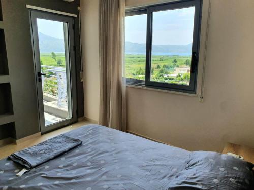 a bedroom with a bed and a large window at Mountain Meets Sea-Spectacular View in Orikum Apartment in Orikum