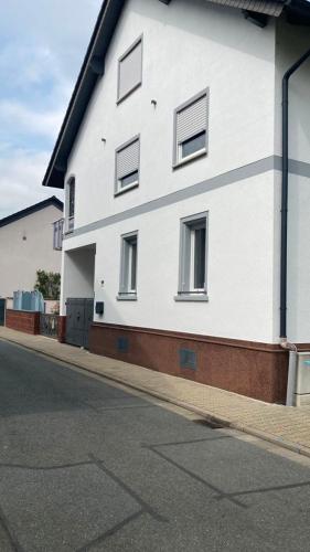 a white building with windows on the side of a street at Ferienwohnung -Isola Madre in Biebesheim