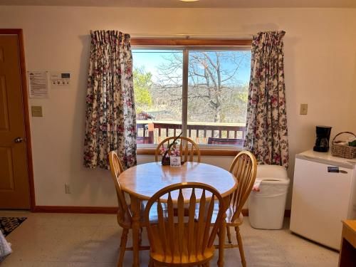a kitchen with a table and chairs and a window at Driftwood Resort Bull Shoals in Bull Shoals