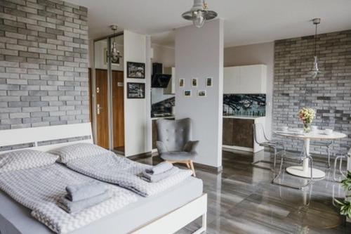 sypialnia z łóżkiem i stołem z krzesłem w obiekcie Łódź Fabryczna Apartament w Łodzi