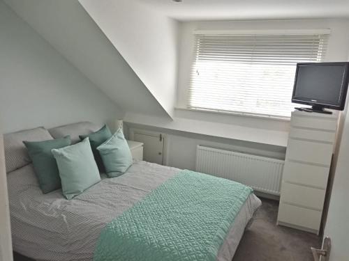 a bedroom with a bed with a television and a window at Lovely one bedroom apartment in Llandudno